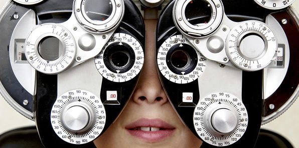 Patient behind a phoropter during an eye exam