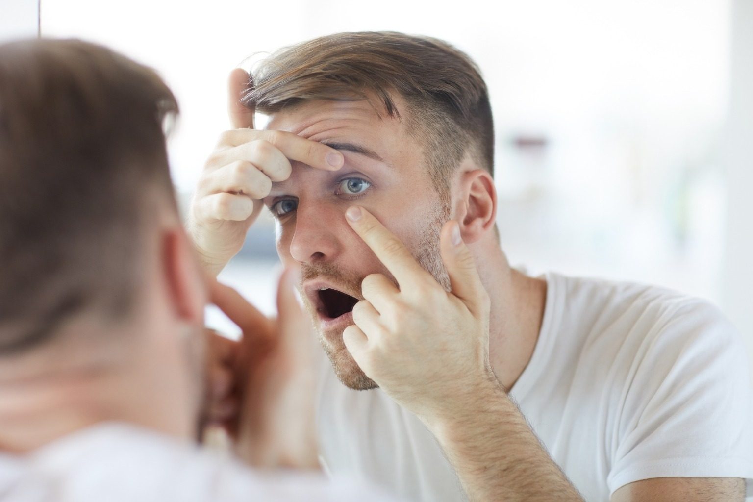 Man checking his eye in a mirror